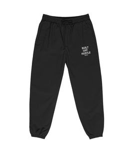 Blakk Apparel recycled tracksuit pants with 'Built Off Hustle' logo - black track pant featuring the phrase 'Built Off Hustle' in stylish white lettering, embodying the brand's ethos of hard work, determination, and success.