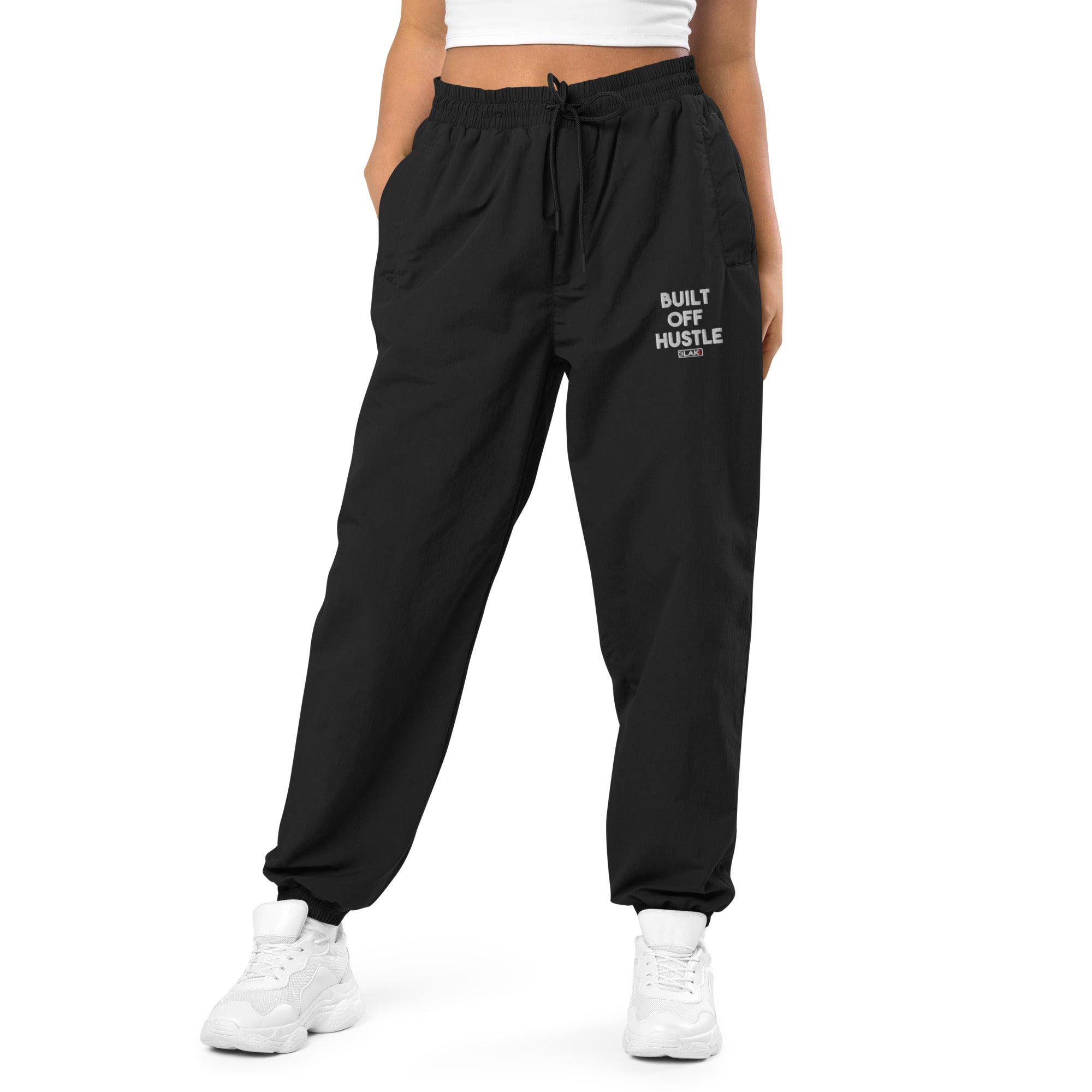 Blakk Apparel recycled tracksuit pants with 'Built Off Hustle' logo - black track pant featuring the phrase 'Built Off Hustle' in stylish white lettering, embodying the brand's ethos of hard work, determination, and success.