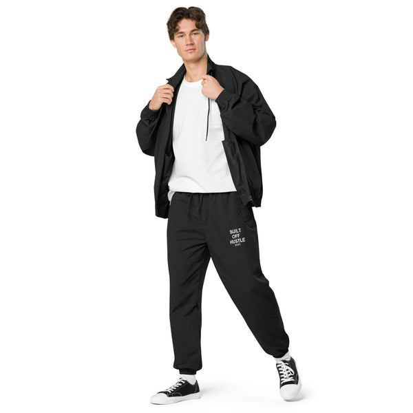 Blakk Apparel recycled tracksuit pants with 'Built Off Hustle' logo - black track pant featuring the phrase 'Built Off Hustle' in stylish white lettering, embodying the brand's ethos of hard work, determination, and success.